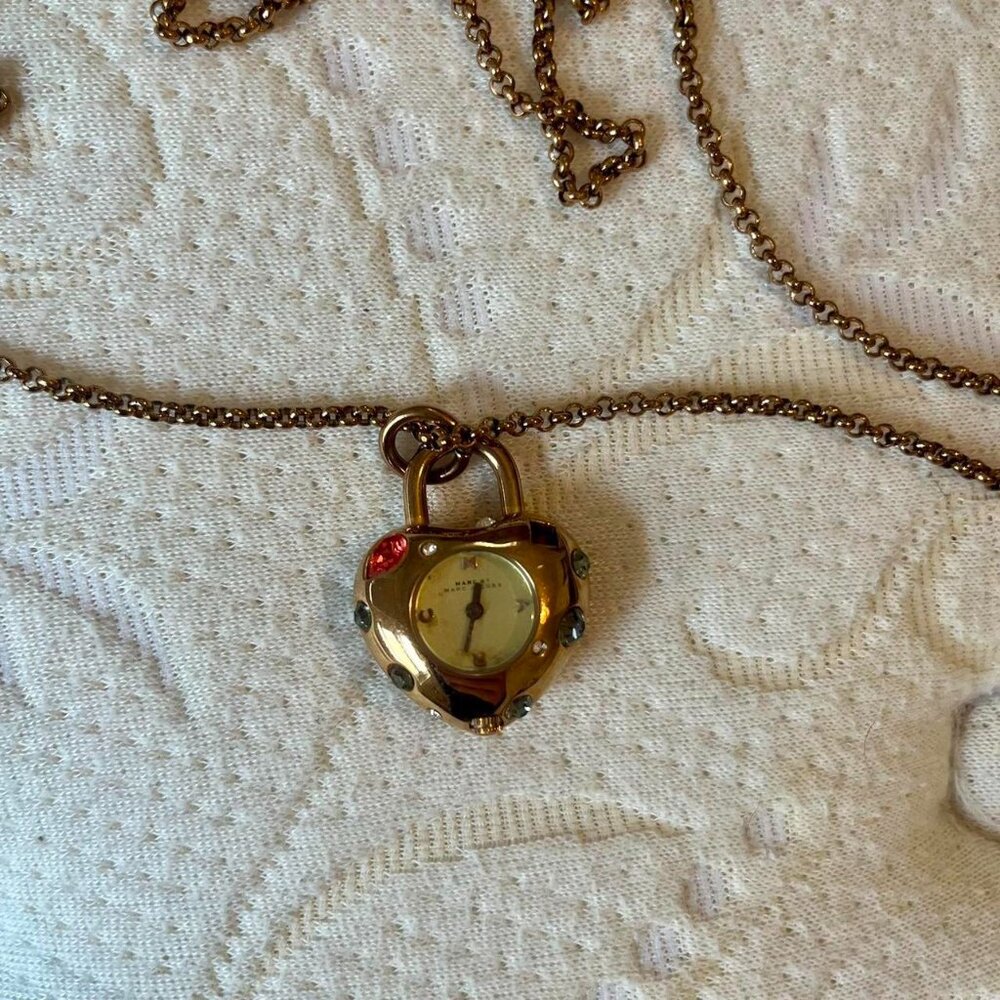 Marc Jacob’s heart shaped clock necklace with a cool gold tone and red accents.